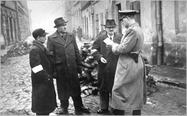 A German policeman checks the identification papers of Jews in the Krakow ghetto